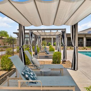 A serene poolside setting with stylish loungers and shaded cabanas perfect for relaxation.