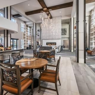 A modern and spacious lobby with stylish furniture and a grand chandelier.