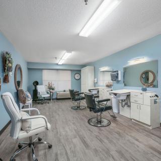 A spacious and well-lit hair salon with multiple styling stations and mirrors.