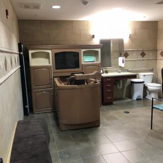 A spacious bathroom with a spa chair and modern amenities.