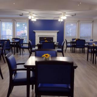 A modern dining area with blue accents, featuring neatly arranged tables and chairs.