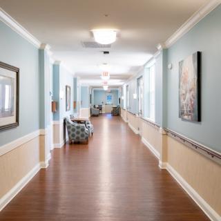 A well-lit hallway with art on the walls and comfortable seating areas.