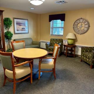 A cozy lounge area featuring a round table, comfortable seating, and decorative elements.