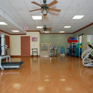 A spacious gym setup featuring various exercise equipment, including treadmills and stationary bikes.