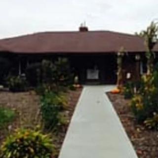 A single-story house with a garden and pathway leading to the entrance.