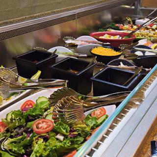 A vibrant salad bar with a variety of fresh vegetables and toppings.