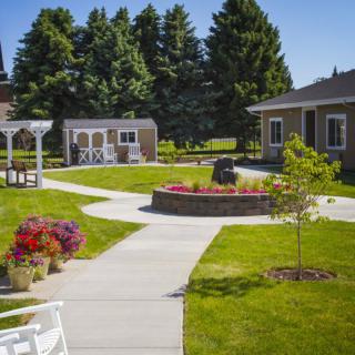 A beautifully landscaped garden with a gazebo, pathways, and vibrant flower arrangements.