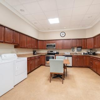 A spacious kitchen featuring wooden cabinets, modern appliances, and a cozy dining area.