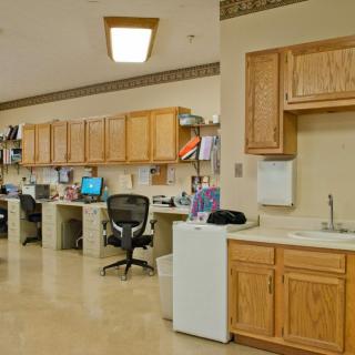 An office workspace with desks, computers, and wooden cabinets.