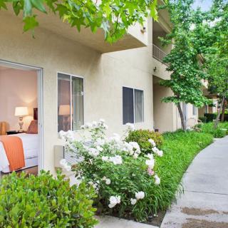 A peaceful apartment exterior with a garden and pathway.