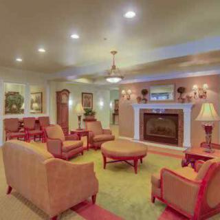 A cozy living room with a fireplace, sofas, and elegant decor.