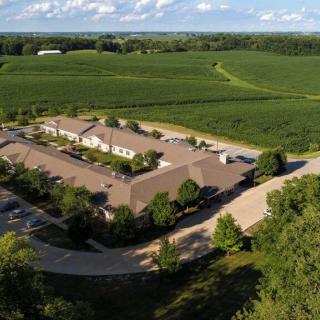 An aerial view of a building surrounded by lush green countryside and fields.