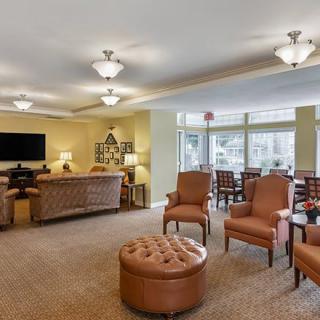 A spacious and well-lit living room with comfortable seating and a TV.