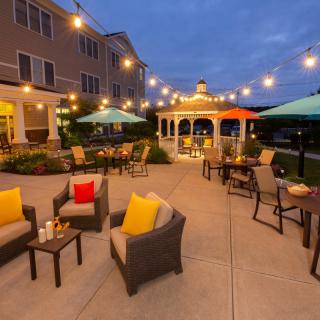A cozy outdoor patio with string lights and comfortable seating.