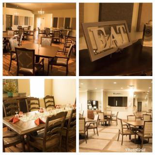 A cozy dining area with neatly arranged tables and chairs, featuring elegant interior decor and a decorative 'EAT' sign.
