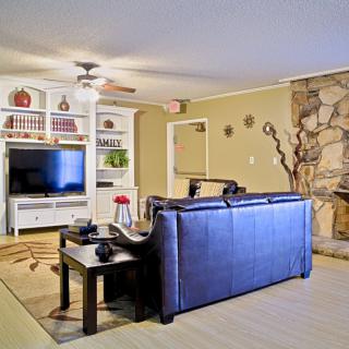 A cozy living room with a sofa, television, bookshelf, and fireplace.