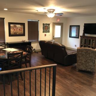 A cozy living room with a sofa, dining area, and television.