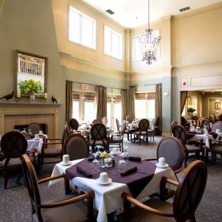 An elegant dining room with neatly arranged tables and a chandelier.