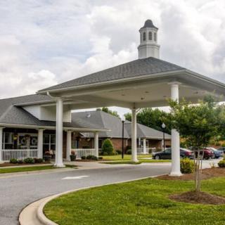 A building with a covered entrance and landscaped surroundings.