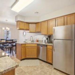 A modern kitchen with wood cabinets and stainless steel appliances.