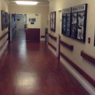A quiet hospital hallway with bulletin boards on the walls.