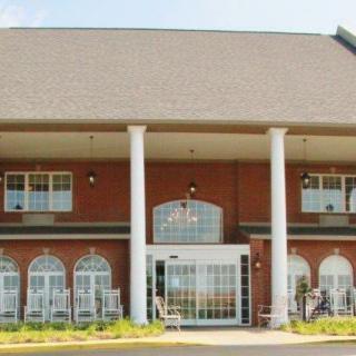 A two-story brick building with large white columns at the entrance.
