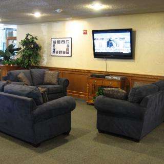 A cozy living room with sofas and a wall-mounted television.