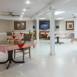 A well-lit dining area with neatly arranged tables and chairs.