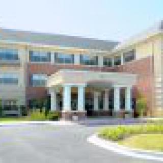 Front view of a modern hospital building with an entrance and columns.