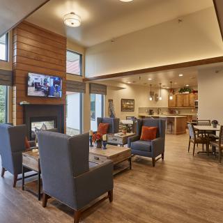 A modern living area with comfortable seating, a fireplace, and an open kitchen layout.