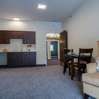 A modern apartment interior featuring a small kitchenette and dining area.
