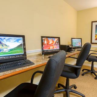 A small office space with multiple workstations featuring computers and chairs.