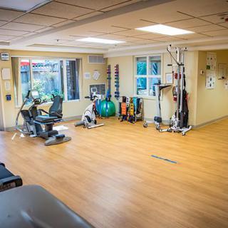 A spacious gym with various exercise equipment and a bright atmosphere.