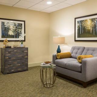 A cozy living room with a gray couch, decorative pillows, and framed artwork on the walls.