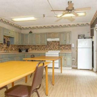 A spacious kitchen and dining area with tables, chairs, and appliances.