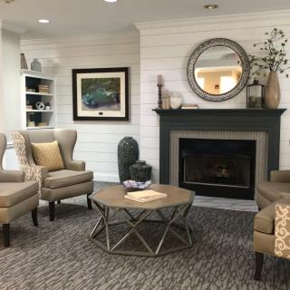 A cozy living room with a stylish fireplace, armchairs, and a coffee table.