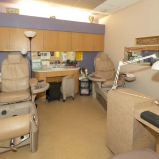 A well-equipped treatment room in a clinic, featuring comfortable chairs and organized workspaces.