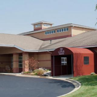 A view of a building with a distinct entrance and landscaped surroundings.