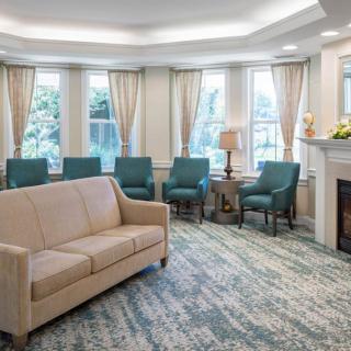A cozy living room with a sofa, chairs, and a fireplace.