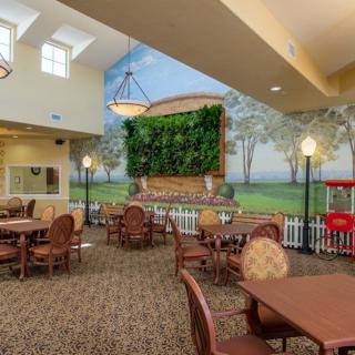A spacious indoor dining area with elegant decor, featuring a mural and a green wall of plants.