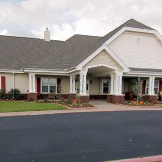A suburban residential building with a well-maintained lawn and driveway.