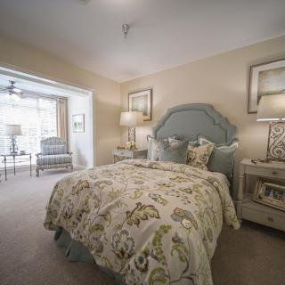 A cozy and elegantly decorated bedroom with a plush bed, stylish bedding, and ambient lighting.