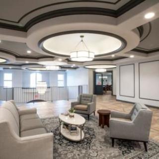 A modern living room with elegant seating and ceiling design.