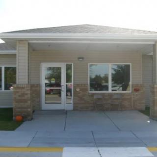 Entrance of a commercial building with large windows and a glass door.
