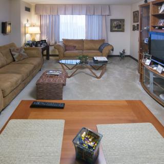 A cozy living room with comfortable seating, a television, and a well-arranged bookshelf.