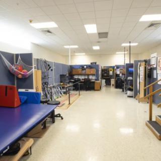 A spacious rehabilitation center equipped with physical therapy and exercise equipment.
