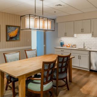 A cozy kitchen and dining area with a wooden table, chairs, and modern lighting.