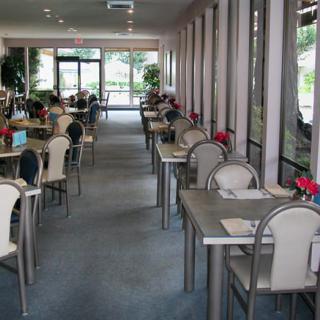 An empty restaurant dining area with neatly arranged tables and chairs.