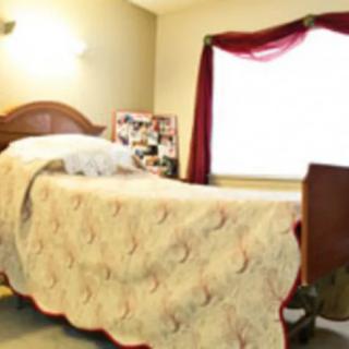 A cozy bedroom with a single bed and a window adorned with red curtains.