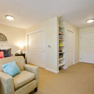 A cozy living room with a comfortable armchair, built-in shelves, and soft lighting.